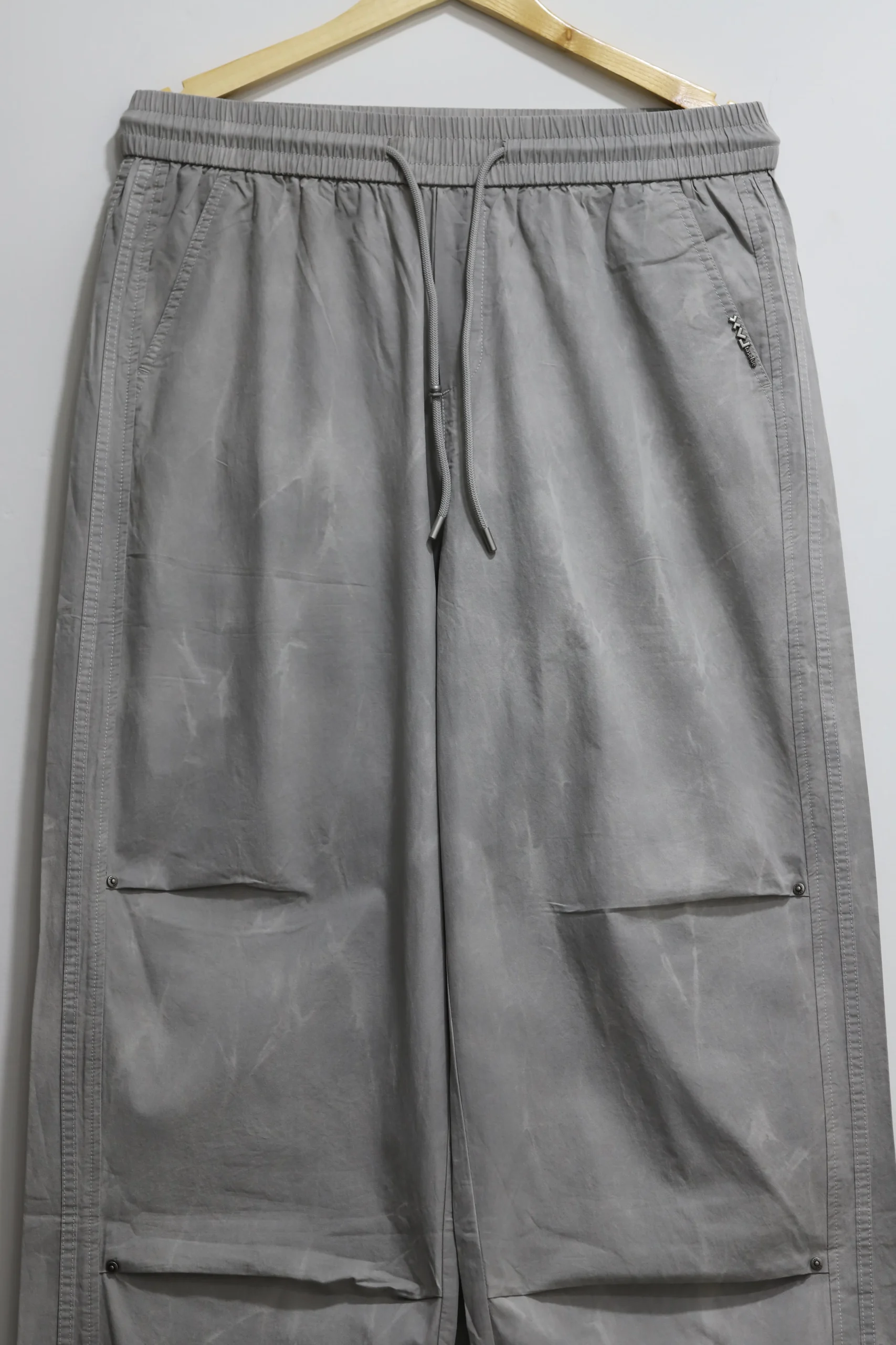 Men's grey baggy fit casual trousers folded cleanly for smart-casual look