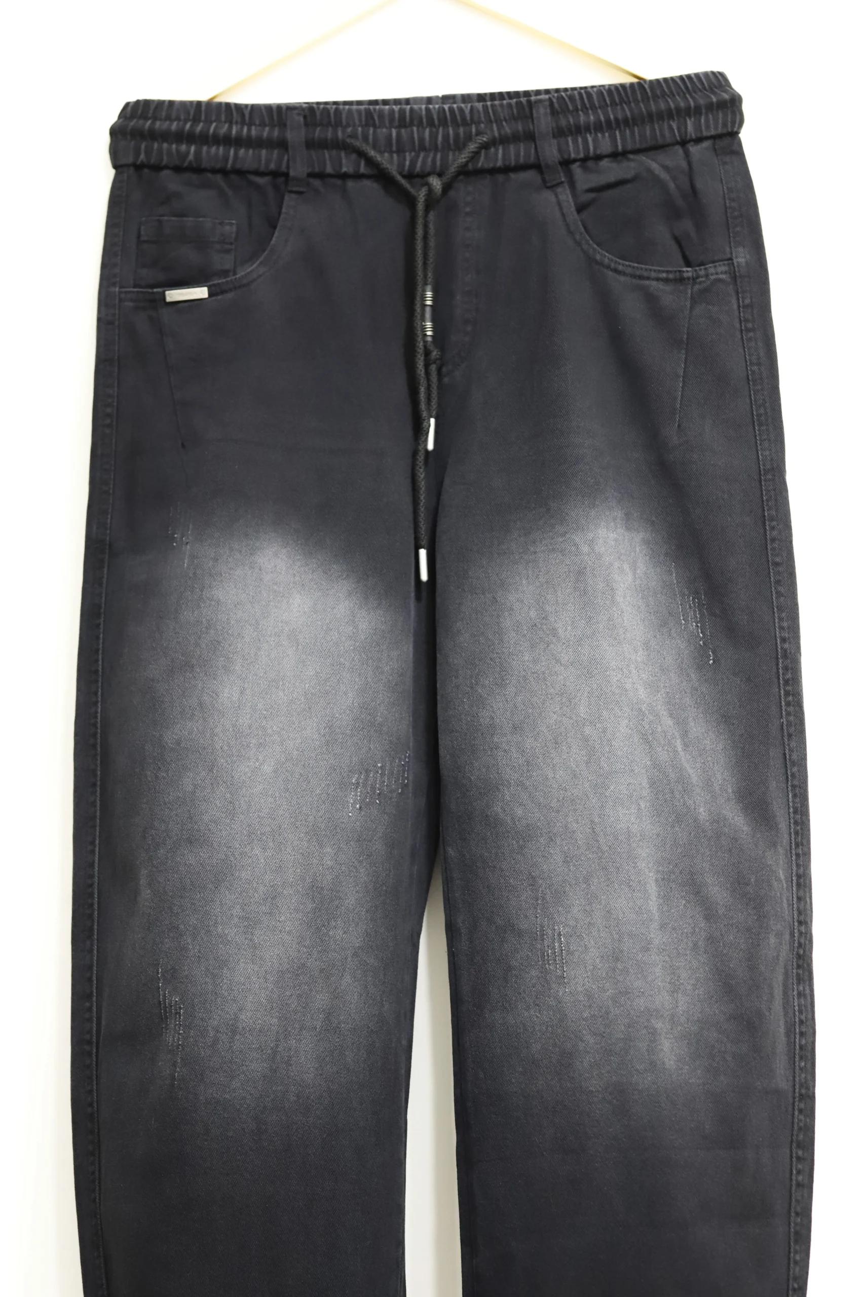 Men's solid jet black baggy fit jeans on hanger showing wide leg cut