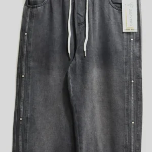 Washed black charcoal baggy denim jeans with elastic waistband and side metal studs