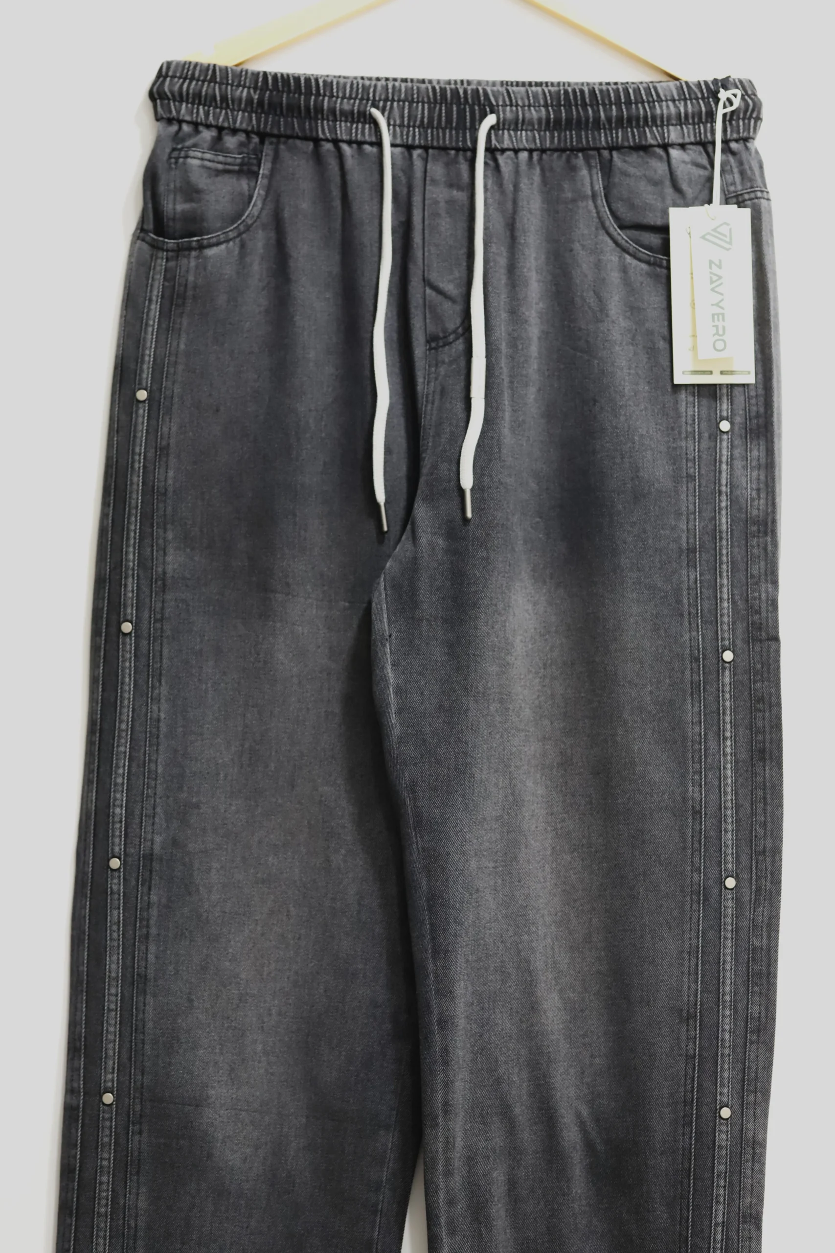 Washed black charcoal baggy denim jeans with elastic waistband and side metal studs